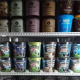 Freezer case with pints of ice cream.