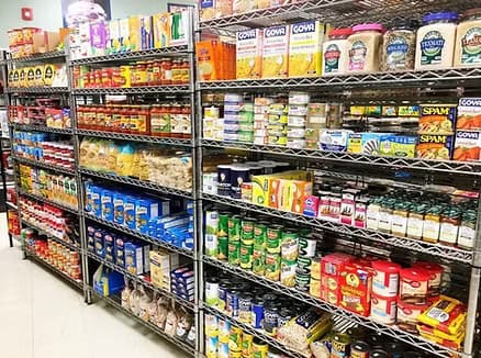 Pantry shelves stocked with canned goods, pasta, and grocery staples.